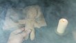 Sorcerer voodoo doll with a pin pierces in the smoke