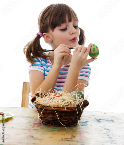 Photo: little girl coloring easter eggs white background little girl coloring easter eggs white background