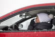 Cute girl with flu symptoms sneezes in a car on snowy day