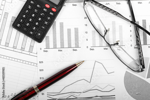 Photo: business finance charts with pen, glasses and calculator business finance charts with pen, glasses and calculator