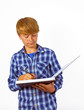 happy smart boy is writing into a book