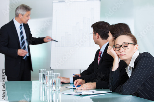 Photo: Bored businesswoman sleeping in a meeting Bored businesswoman sleeping in a meeting