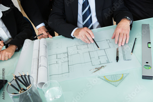 Photo: Architects discussing a blueprint Architects discussing a blueprint