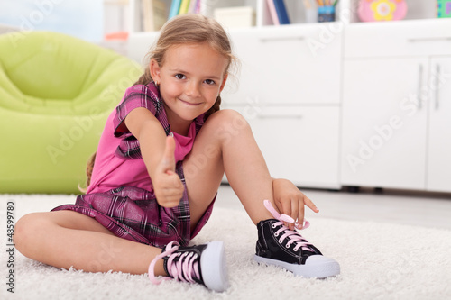 Photo: Little girl learning how to tie her shoes Little girl learning how to tie her shoes