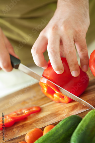 Photo: man cutting vegetables for salad man cutting vegetables for salad