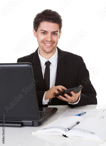 Photo: Young accountant making calculations Young accountant making calculations