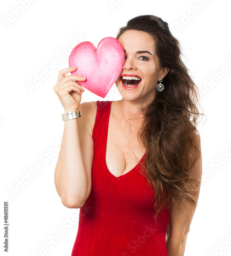 Photo: Laughing woman holding a love heart over her eye. Laughing woman holding a love heart over her eye.