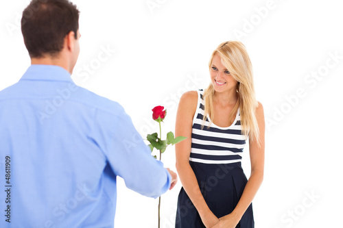 Photo: young man giving rose to a beautiful young woman young man giving rose to a beautiful young woman