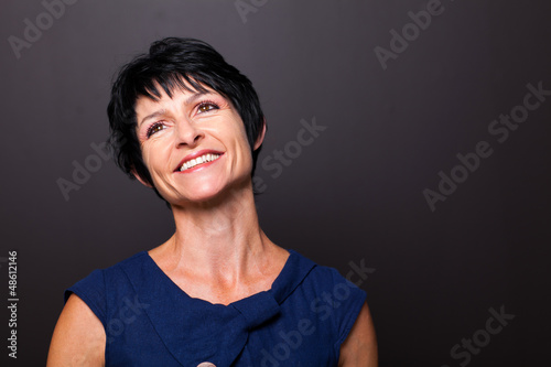 Photo: optimistic middle aged woman portrait on black background optimistic middle aged woman portrait on black background