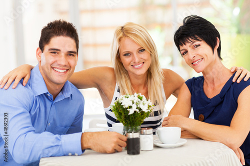 Photo: happy young man with wife and mother-in-law in cafe happy young man with wife and mother-in-law in cafe