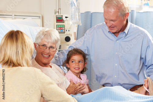 Photo: Family Visiting Senior Female Patient In Hospital Bed Family Visiting Senior Female Patient In Hospital Bed
