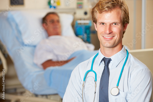 Photo: Portrait Of Doctor With Patient In Background Portrait Of Doctor With Patient In Background