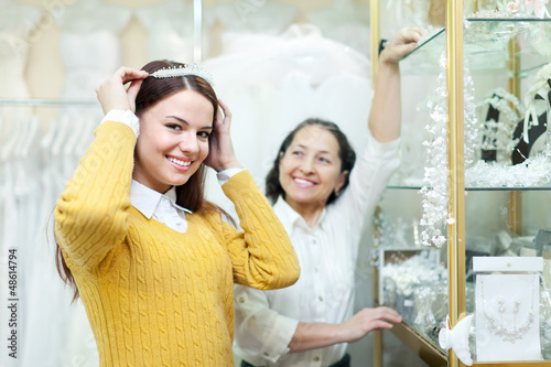 Photo: woman helps the bride in choosing bridal diadem woman helps the bride in choosing bridal diadem