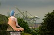 Seated meditating Buddha in views busy container seaport