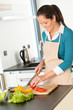Photo: Happy woman cutting tomato kitchen preparing salad Happy woman cutting tomato kitchen preparing salad
