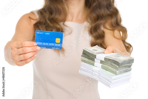 Photo: Closeup on woman giving credit card and money packs Closeup on woman giving credit card and money packs