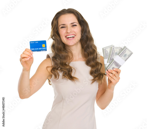 Photo: Happy young woman holding credit card and dollars packs Happy young woman holding credit card and dollars packs