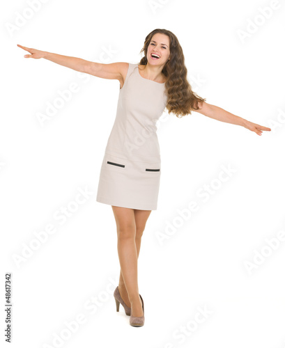 Photo: Full length portrait of happy young woman balancing Full length portrait of happy young woman balancing