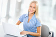Foto: Portrait of young woman using laptop Portrait of young woman using laptop