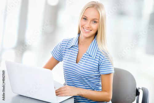 Photo: Portrait of young woman using laptop Portrait of young woman using laptop
