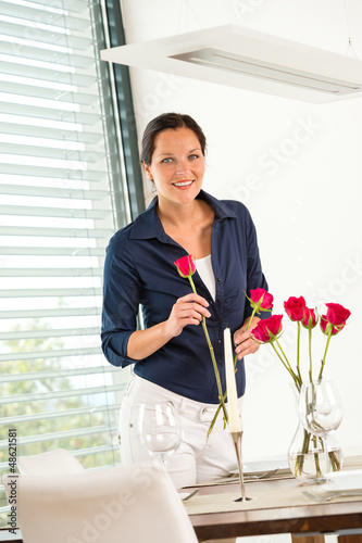 Photo: Happy woman putting bouquet dinner table Happy woman putting bouquet dinner table