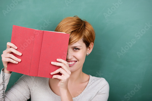 Photo: junge frau mit buch vor der tafel junge frau mit buch vor der tafel