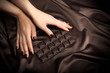 Closeup of female hands touching the dark chocolate bar