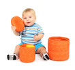 Little boy playing with color wicker boxes, isolated on white