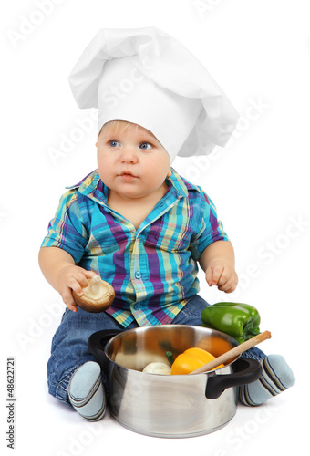 Photo: Little boy in chef's hat with pan and vegetables, isolated Little boy in chef's hat with pan and vegetables, isolated