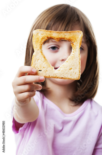 Photo: little girl looking through bread - white background little girl looking through bread - white background