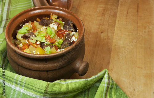 Photo: Meat and vegetables with sour cream and green celery in a pot Meat and vegetables with sour cream and green celery in a pot
