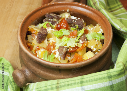 Photo: Meat and vegetables with sour cream and green celery in a pot Meat and vegetables with sour cream and green celery in a pot