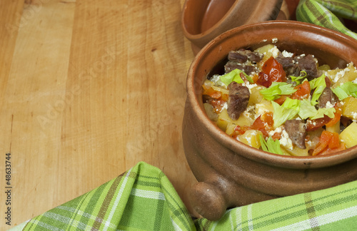 Photo: Meat and vegetables with sour cream and green celery in a pot Meat and vegetables with sour cream and green celery in a pot