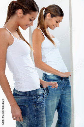 Photo: Brunette trying on jeans Brunette trying on jeans