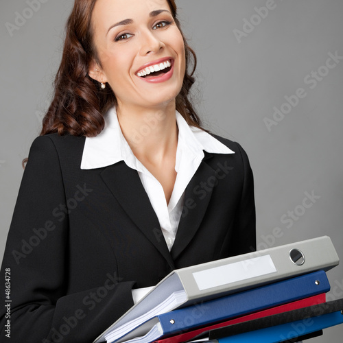 Photo: Businesswoman with folders, on gray Businesswoman with folders, on gray