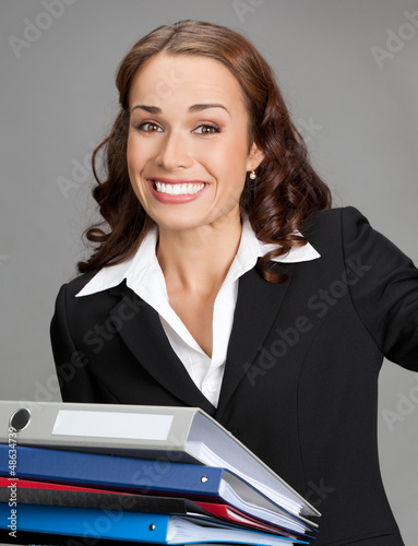 Photo: Businesswoman with folders, on gray Businesswoman with folders, on gray