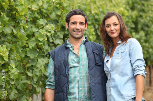 Photo: Couple standing amidst the vines Couple standing amidst the vines