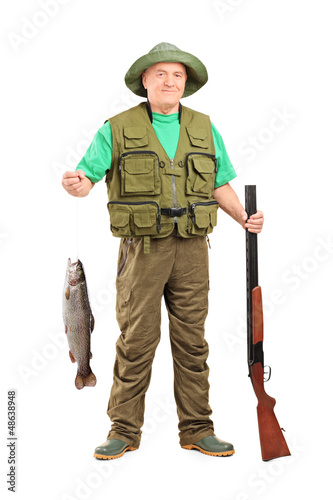 Photo: Mature hunter with shotgun holding a fish Mature hunter with shotgun holding a fish