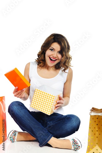Photo: Excited young girl opening present box isolated on white Excited young girl opening present box isolated on white