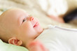 Cute newborn baby smiling in bed