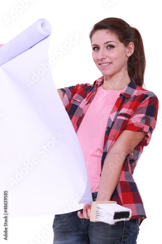 Photo: Young woman holding wallpaper and glue brush Young woman holding wallpaper and glue brush