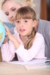 Little girl and mother looking at globe
