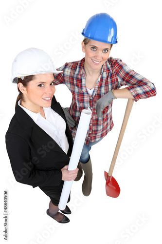Photo: Blue collar worker standing next to an engineer Blue collar worker standing next to an engineer