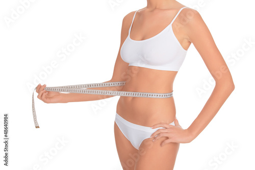 Photo: fit young woman measuring her waistline fit young woman measuring her waistline