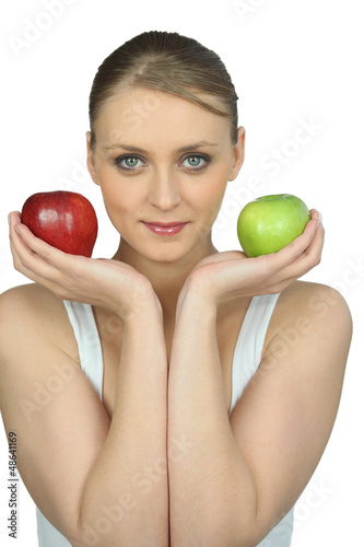 Photo: Young woman holding a red and a green apple Young woman holding a red and a green apple