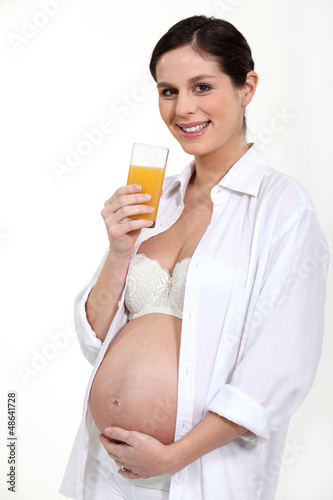 Photo: Pregnant woman drinking a glass of juice Pregnant woman drinking a glass of juice