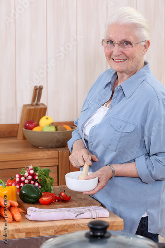 Photo: Woman using a pestle and mortar in the kitchen Woman using a pestle and mortar in the kitchen