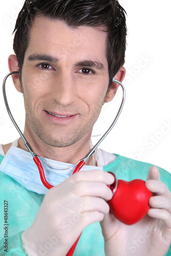 Photo: Young doctor listening to a model heart through a stethoscope Young doctor listening to a model heart through a stethoscope