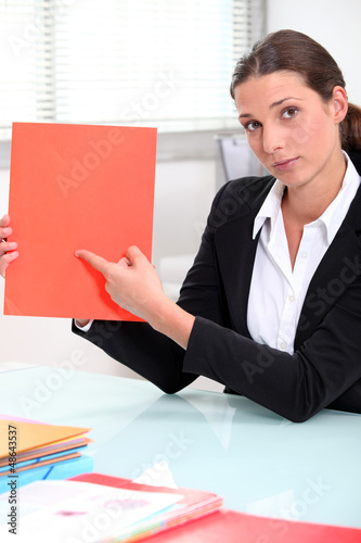 Photo: businesswoman pointing to a file left blank for your image businesswoman pointing to a file left blank for your image