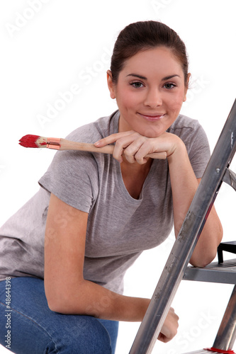 Photo: Woman with paint brush leaning on a ladder Woman with paint brush leaning on a ladder